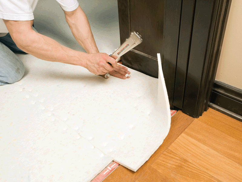 Person installing flooring underlayment from Triangle Flooring Center in Carrboro, North Carolina