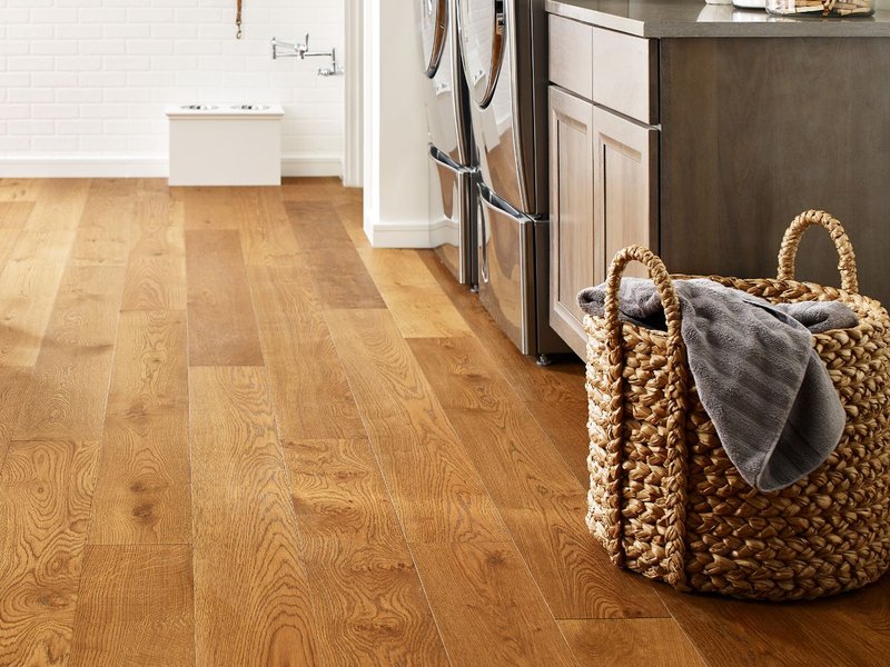 Basket of laundry in a kitchen with wood-look luxury vinyl flooring from Triangle Flooring Center in Carrboro, North Carolina